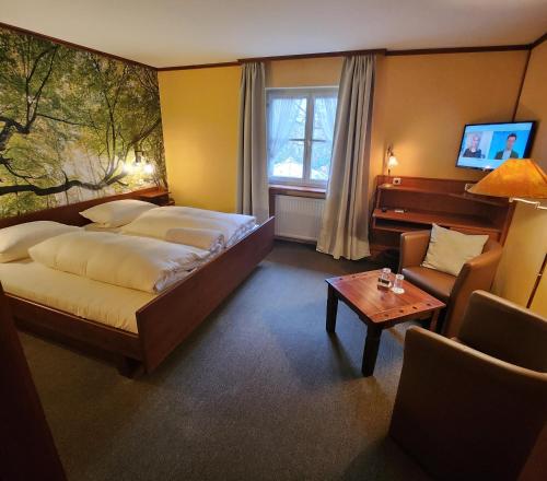 索梅劳森Hotel & Restaurant Sonnenhöfle的酒店客房配有床、沙发和桌子。