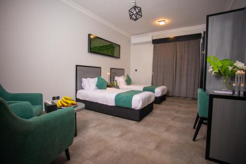 迈季迈阿Karims Hotel的酒店客房,配有两张床和两把椅子