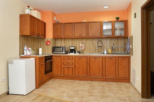 鲁塞Детелина的厨房配有木制橱柜和白色冰箱。