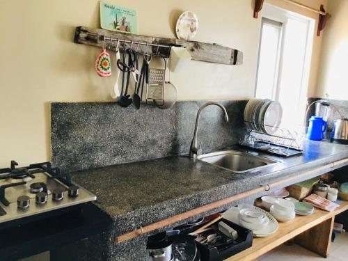 普瓦尼梅查恩加尼Nakupenda Malaika Flat的厨房柜台设有水槽和炉灶。