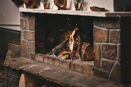 切佩拉雷Хотел Феникс的砖砌壁炉,壁炉里放着火