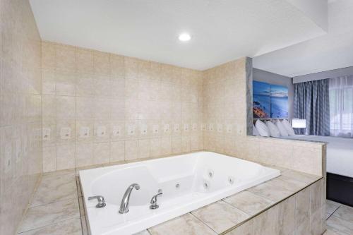奥兰多北奥兰多戴斯酒店的带窗户的浴室设有大浴缸