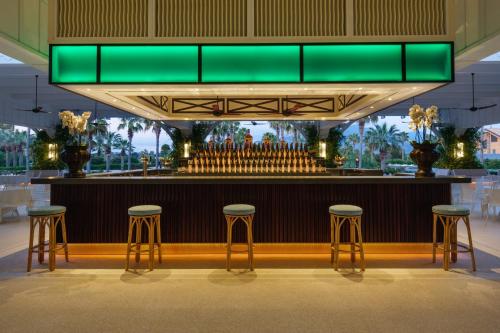 帕埃斯图姆Savoy Hotel & Spa - Preferred Hotels & Resorts的酒吧设有凳子和绿色天花板