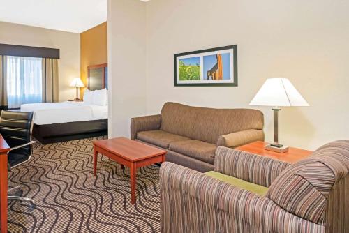 米德韦斯特城La Quinta by Wyndham Midwest City - Tinker AFB的酒店客房设有一张沙发和一张床