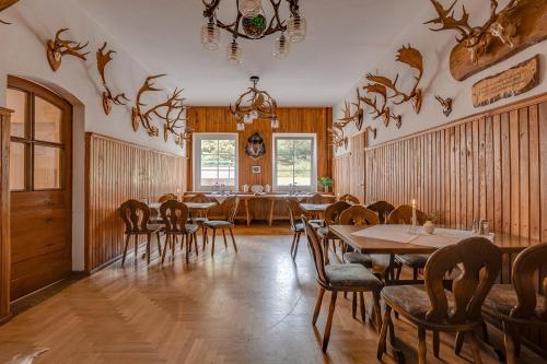 费尔德伯格Waldhotel & Restaurant Stieglitzenkrug的一间带桌椅和吊灯的用餐室