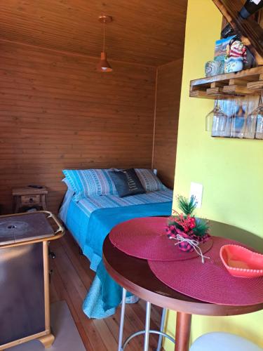 邦雅尔丁-达塞拉Pousada Chales Aconchego Serrano的卧室配有一张床和一张桌子