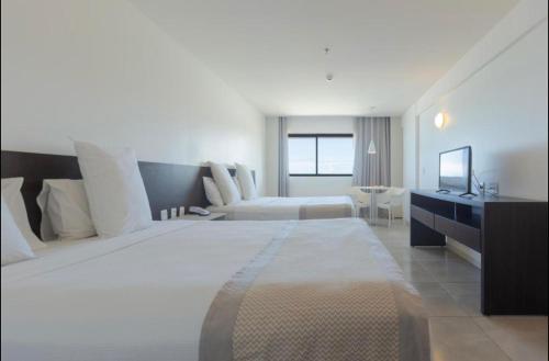马塞约Flat novo à Beira-mar的大型酒店客房设有一张大床和一张沙发。
