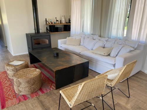 圣拉斐尔Posada Miss Olivos的客厅配有白色沙发和壁炉