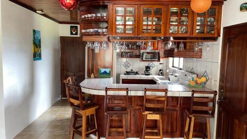 福尔图纳Las Pavitas Cottages的一个带木制橱柜的厨房和一个带椅子的岛屿