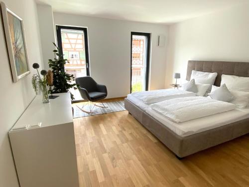 SalensteinFeWo Bodenseewest的白色卧室配有床和椅子