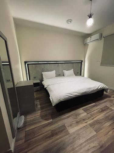 欧拉sky hotel的一间卧室配有一张铺有木地板的白色床单。