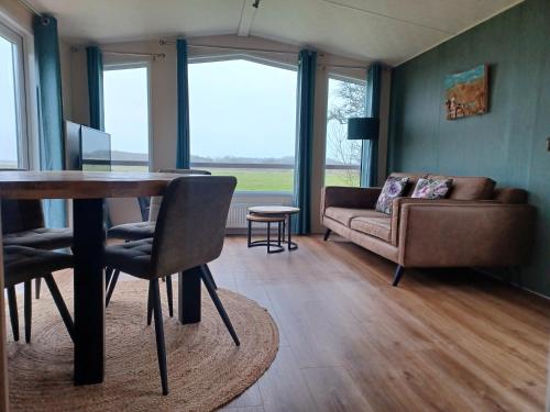 德科克斯多普Chalet duunzicht Texel的客厅配有桌子和沙发