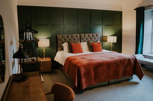 GilslandDacre House, Gilsland的一间卧室配有一张带橙色枕头的大床
