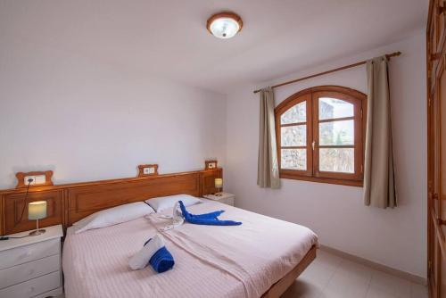 查德尔帕罗奥Precioso apartamento para nudistas y naturistas.的一间卧室配有一张带蓝色毛巾的床