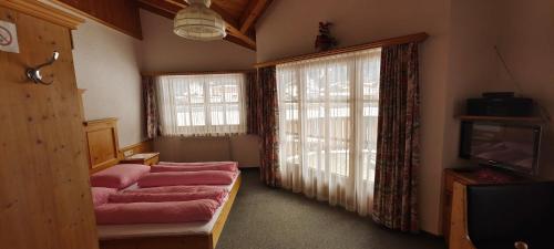 胡本Ferienwohnungen Stabentheiner的客厅配有粉色家具和大窗户