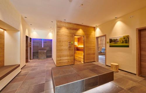 KirchrothBachhof Resort Apartments的房屋的走廊,设有木墙和瓷砖地板