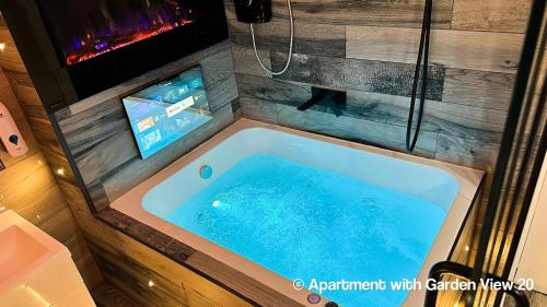 布雷得佛Serenity Apartments Bradford的浴室设有按摩浴缸和电视。