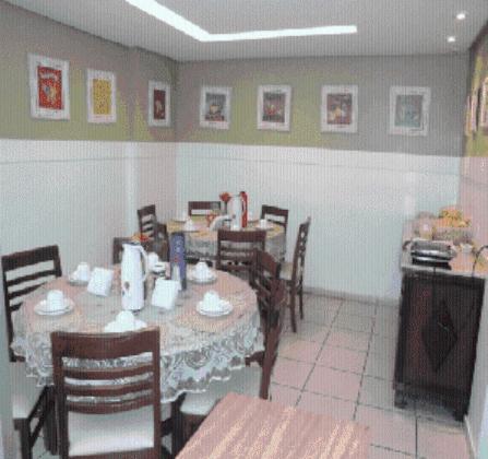 贝洛奥里藏特Hospedagem Chamonville的餐厅内带桌椅的用餐室