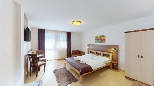 特尔乔夫法特拉酒店的一间卧室配有一张床、一张桌子和一把椅子