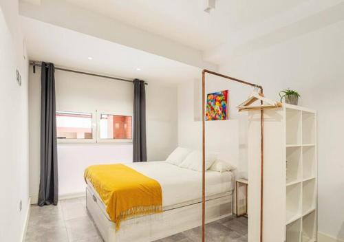 马拉加LoftinMalaga的白色的卧室设有床和窗户