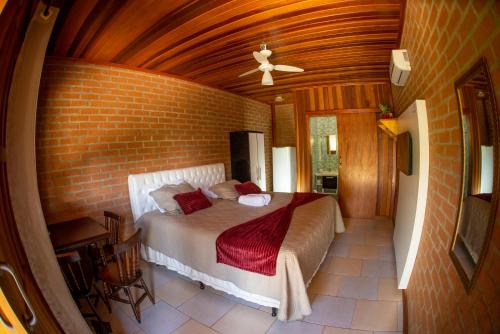 圣本图-杜萨普卡伊Chalés Sapucaí Pousada的一间卧室设有一张床和砖墙