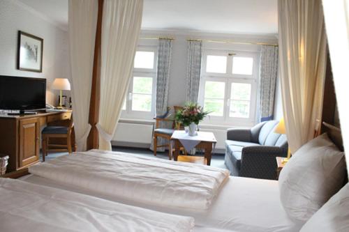 汉恩明登阿尔特帕克霍夫酒店的一间卧室设有一张床和一间客厅。