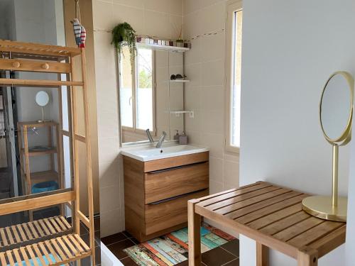 萨尔拉拉卡内达Ô Clair de Lune Chambres d'hôtes climatisées à Sarlat - parking privé - piscine chauffée - espace bien-être Jacuzzi et massages的一间带水槽、镜子和桌子的浴室