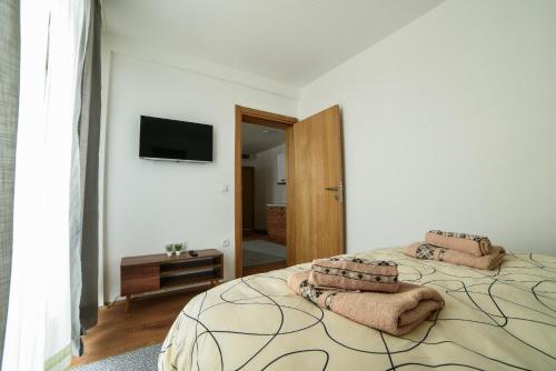 科帕奥尼克Apartman La Foresta Kopaonik的一间卧室配有一张大床和毛巾