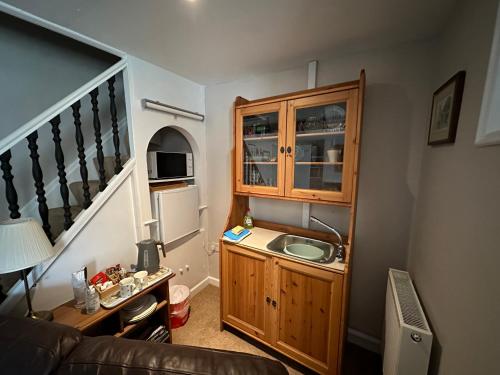 布里德波特Cottage en-suite room with private lounge的一个带水槽和橱柜的小厨房