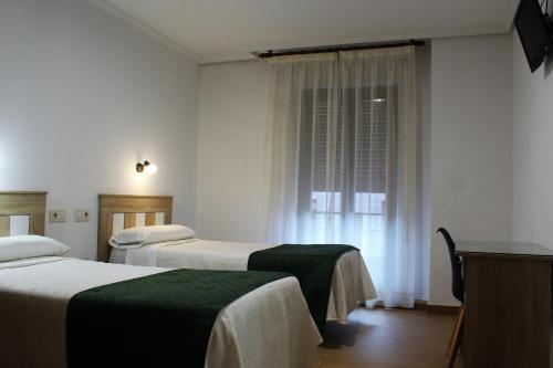 托莱多马德里旅馆的酒店客房设有两张床和窗户。