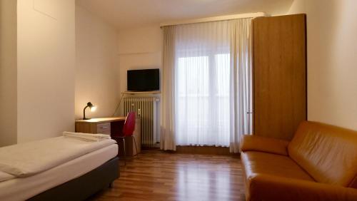 慕尼黑皮加苏斯酒店的酒店客房设有床、沙发和窗户。