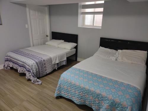阿贾克斯Prestige Accommodation Self-contained 2 Bedrooms Suite的一间卧室配有两张床和一张床套