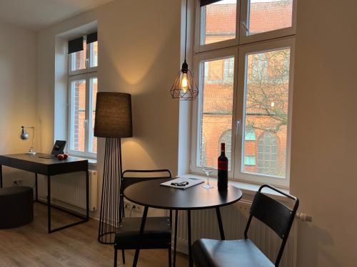 布克斯泰胡德Apartmenthaus Buxtehude St -Petri-Platz Studiowohnung 3的客厅配有桌子和一瓶葡萄酒