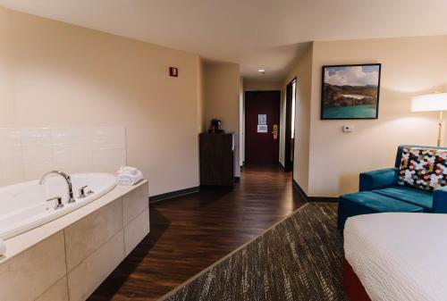 波特兰波特兰市场酒店的酒店客房设有浴缸、一张床和椅子