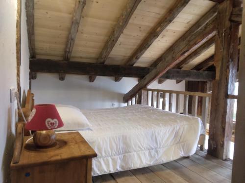 蒙查往Chalet La Plagne jacuzzi vue top的一间卧室配有一张床和一张桌子上的红灯