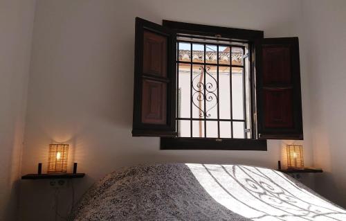 格拉纳达Casa Carmen的一间卧室设有一张床和一个窗口