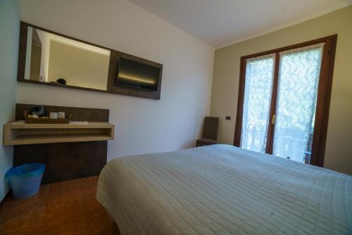 Rocchetta Nervina拉歌宾酒店的一间卧室配有一张床、镜子和窗户