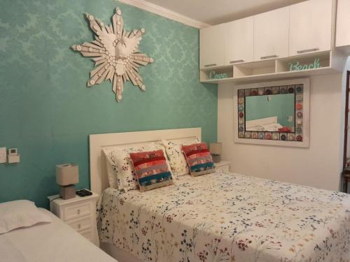 马利西亚斯Linda Casa Condomínio Maresias的卧室配有一张床,墙上挂着雪花时钟
