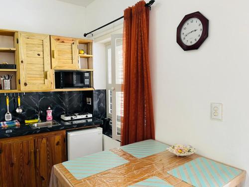 威廉斯塔德Catherine Suites的厨房配有桌子和墙上的时钟