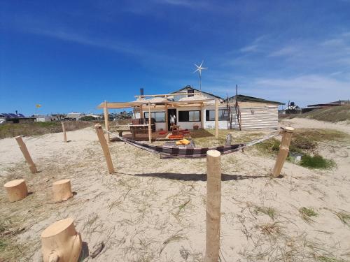 凯博波洛尼奥La Pequeña Hostel的沙滩上的房屋,沙滩上有船