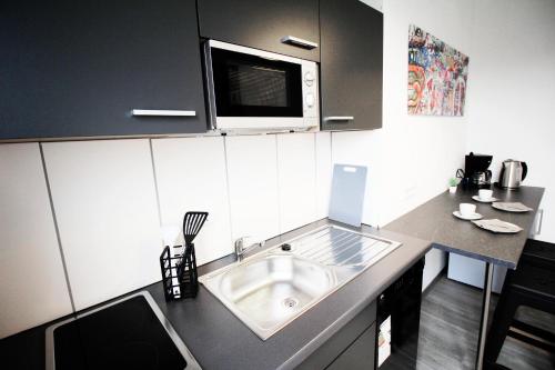 杜伊斯堡SH Team Lodges 4 Apartments für max 19 Personen l Monteure l Messe l Business的厨房配有水槽和微波炉