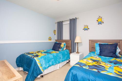 基西米Family Friendly 4 Bedrooms with GameRoom close to Disney in Compass Bay 5103的一间卧室配有两张带蓝色棉被的床