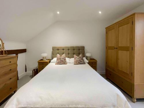 大邓莫Immaculate barn annexe close to Stansted Airport的卧室配有一张带两个枕头的大白色床