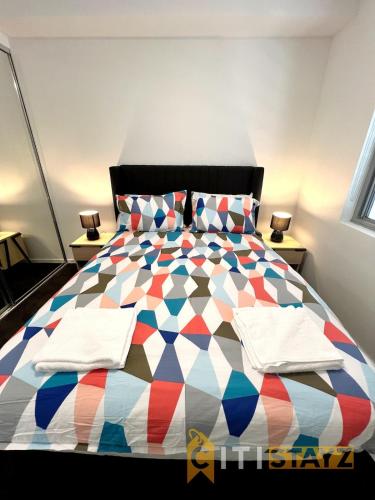 贝尔康嫩Bold in Bruce - 1bd 1bth 1csp的一间卧室配有一张色彩缤纷的床和2个床头柜