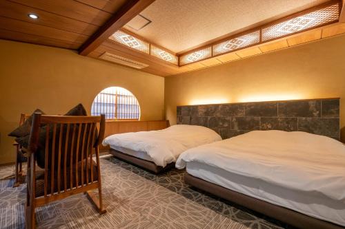 秦野市Jinya Ryokan的一间卧室设有两张床和窗户。