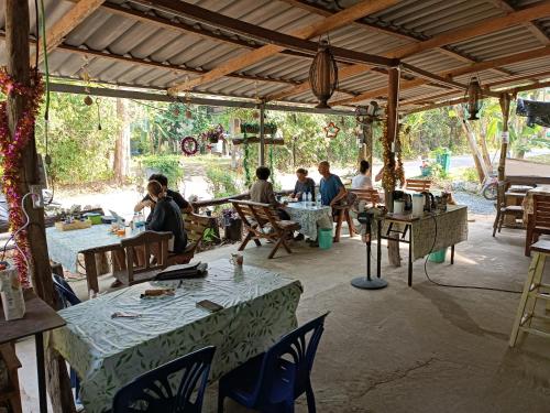 Ban Lak UanGood Time Resort Koh Kood的坐在庭院桌子上的一群人