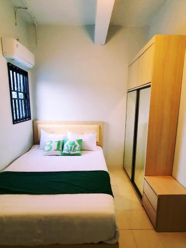 名古屋Homestay 81 Batu Batam的卧室配有带绿色枕头的大型白色床