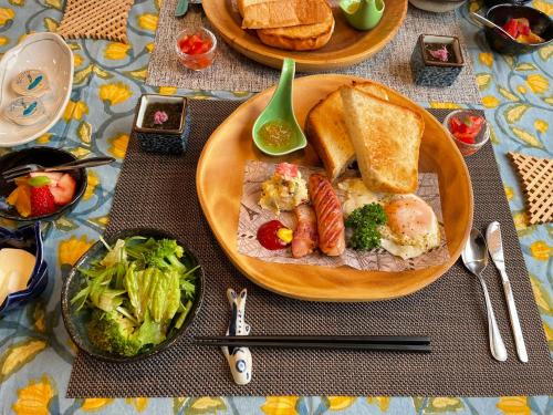 座间味村Dining & Stay 38 Miyahira的餐桌,上面有一盘食物,包括面包和蔬菜