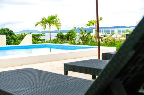 石垣岛Blue Ocean Resort的一个带两把椅子和一张桌子的游泳池