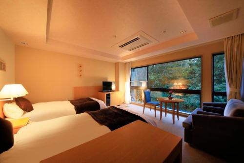 日光四季彩酒店(Hotel Shikisai)的酒店客房设有两张床和大窗户。